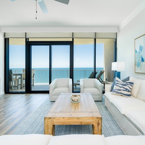 Relax in the airy living area with a large sectional, coastal decor, and stunning beach views