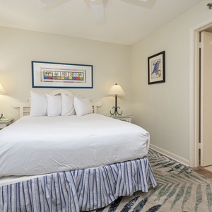 Rest in this inviting guest bedroom featuring a queen bed, bedside lamps, and vibrant decor that enhances comfort