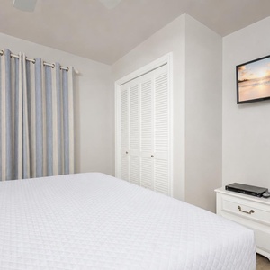 Soft quilt invites you to rest in the guest suite while the TV offers a calming escape after your day