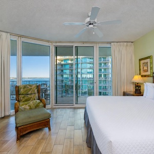 Enjoy peaceful mornings in the king master suite, relaxing on the comfy chair while soaking in stunning bay views