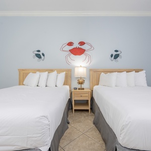 Rest in this guest room on a queen bed after a day at the beach, with soothing decor creating a calming retreat