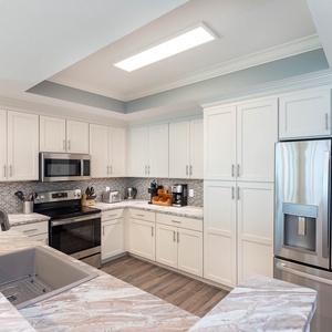 Prepare meals in this kitchen with elegant cabinetry, stainless appliances, and stylish countertops