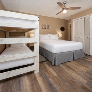 This cozy guest bedroom features a charming twin bunk bed and a comfortable full bed, perfect for family getaways