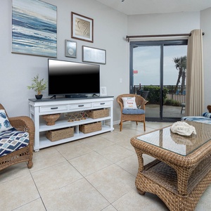Unwind in the inviting living area, featuring comfortable seating, a TV, and easy access to outdoor patio views