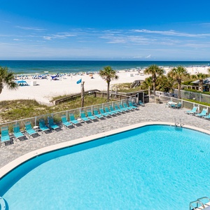 This inviting view showcases a sparkling pool surrounded by lounge chairs, with a stunning beach just steps away