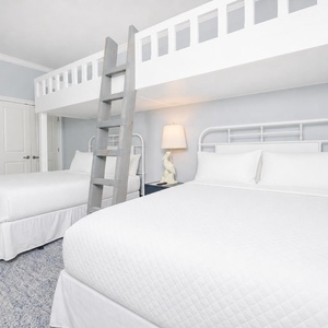 Enjoy a cozy retreat in the bunk room with two queen beds and two lofted twins