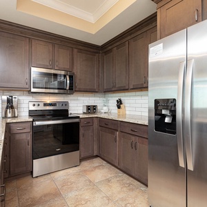 Create delicious meals in this kitchen, equipped with stainless appliances, rich wooden cabinetry, and coffee corner
