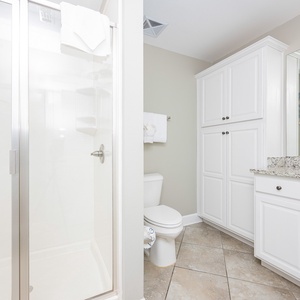 Enjoy a relaxing shower after a day at the beach in this guest bath with stylish cabinetry and spacious vanity