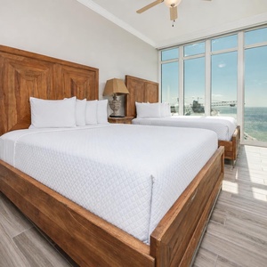 Wake to a breathtaking sunrise in this queen guest suite with two cozy beds and expansive views from the windows