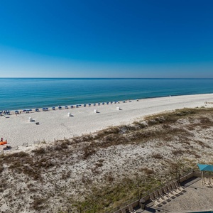 Relax on the spacious balcony while enjoying the serene views of the beach and calm waters just steps away