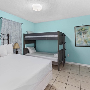 Guest bedroom featuring a cozy queen bed and a stylish twin bunk bed, perfect for family or group stays
