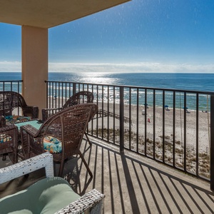 Relax on the balcony with comfortable wicker seating and enjoy breathtaking views of the sandy beach and sparkling waters