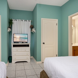 Cozy guest room featuring two queen beds, a TV, and an adjoining bathroom for convenience