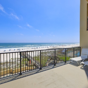 Relax on the balcony with inviting lounge chairs and breathtaking views of the serene beach and sparkling waters