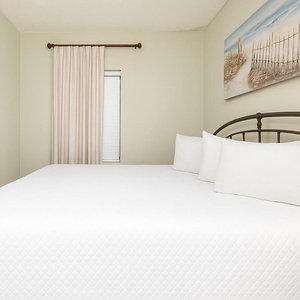 Enjoy a peaceful night in this guest bedroom, enhanced by king bedding and a charming coastal vibe