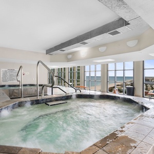 Relax in the inviting hot tub at The Oasis in Orange Beach with stunning beachfront views through large windows