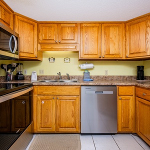 The kitchen features warm wood cabinetry, granite countertops, and stainless appliances, creating a welcoming space