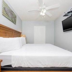 Retreat to this serene guest bedroom featuring a king bed, flat-screen TV, and coastal decor for a restful stay