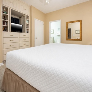 Inviting guest bedroom features a king bed, ample storage, and a wall-mounted TV, creating a cozy retreat for relaxation