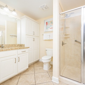 Enjoy a relaxing shower after a day at the beach in this guest bath with stylish cabinetry and spacious vanity