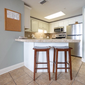 Enjoy casual meals at the breakfast bar with wooden stools, surrounded by a bright and inviting kitchen space