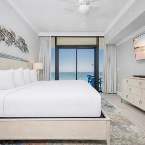 Tranquil master bedroom featuring a plush king bed, fluffy pillows, and beachfront balcony access