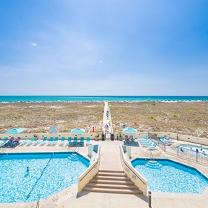 Take a refreshing dip in the pool while enjoying the vibrant beach vibe just steps away from your retreat