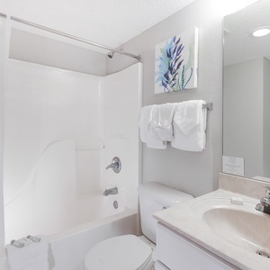 Refresh in this bathroom featuring a spacious tub-shower, vanity, and soft towels for your comfort