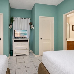 Cozy guest room featuring two queen beds, a TV, and an adjoining bathroom for convenience