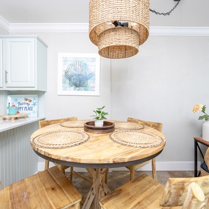 Inviting dining area featuring a rustic wooden table, woven placemats, and charming coastal decor