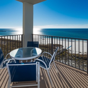 Balcony seating for four offers a serene view of the sparkling gulf and white sand beach, perfect for relaxation