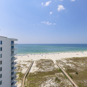Expansive beachfront view showcasing vibrant umbrellas on the white sand, inviting guests to relax by the tranquil waters