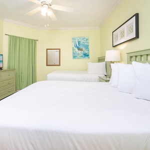 Relax in this cheerful guest room featuring two comfortable double beds, a TV, and vibrant decor for a refreshing stay