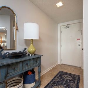 Step into a welcoming entryway featuring a stylish console table, decorative lamp, and a charming mirror