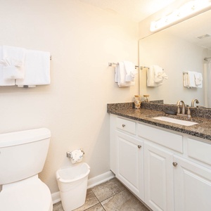 Experience the guest bathroom featuring a spacious countertop, fresh towels, and a relaxing shower area for your comfort