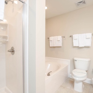Indulge in a rejuvenating soak in the soothing tub or refreshing rinse in the shower, surrounded by soft towels