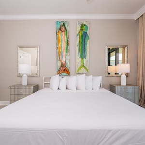 Serene master bedroom with a large king bed, vibrant fish artwork, and stylish nightstands