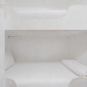 This cozy space features a bunk bed and a view of the beach, with a bright living area just steps away