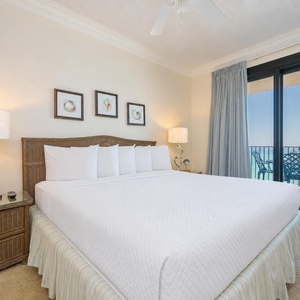 Relax in this master bedroom featuring a king bed, soft lighting, and beachfront balcony access