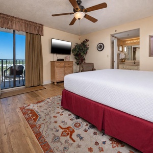 The master features a large king bed, a TV for entertainment, and a lovely view through sliding glass doors