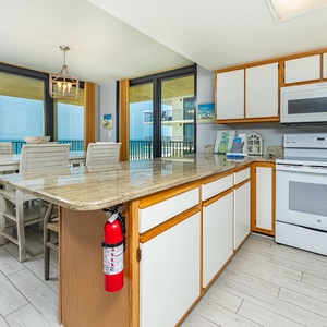 Bright kitchen featuring granite countertops, white cabinetry, and a breakfast bar, perfect for meals or enjoying coffee