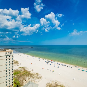 Breathe in the fresh air while enjoying panoramic views of the tranquil waters and vibrant beach from the balcony