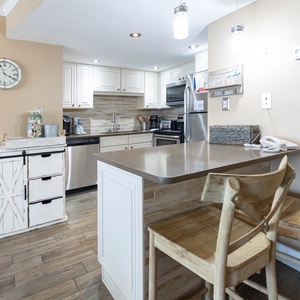 Elegant kitchen featuring modern stainless appliances, Keurig and coffee maker, and rustic wooden accents for a cozy feel