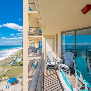 The balcony features comfortable seating with a view of the beach and pool area, perfect for relaxation in the sun