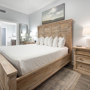 Relax in this elegant king master suite with fluffy pillows and coastal decor