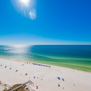 Enjoy breathtaking beachfront views from the balcony, with vibrant umbrellas dotting the sandy shore below