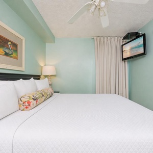 Fluffy pillows invite you to relax in the king suite for a calm movie night after a fun day at the beach