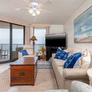 Relax in this inviting living area, featuring comfortable seating, a large TV, and views through sliding glass doors