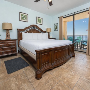 The elegantly furnished master suite features a king bed, wooden accents, and a sliding door leading to a private balcony