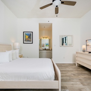 Guest bedroom featuring a cozy queen bed, modern decor, a flat-screen TV for relaxation, and balcony access